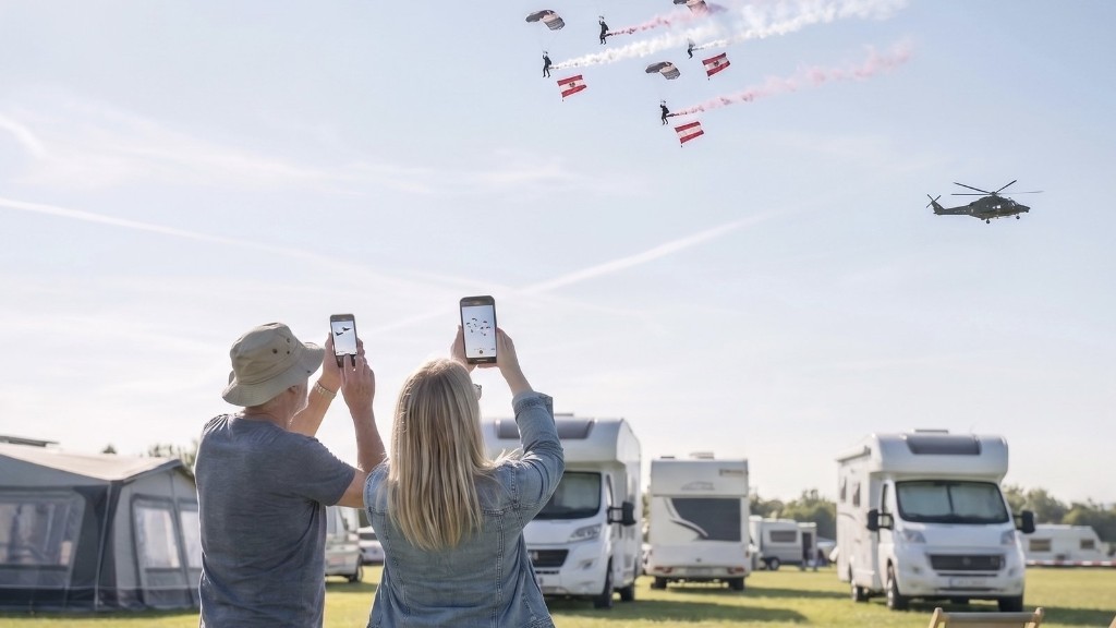 Campinggäste fotografieren Fallschirmsprung-Show beim Schitterhof Camping
